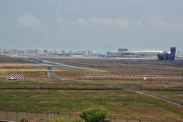 Runway lights running out to the terminal building and control tower across the airfield — Dhruva, Karanjade