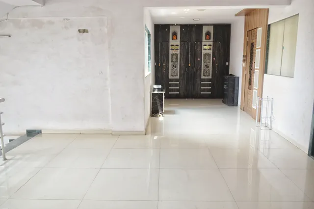 Glossy tiled common landing looking along to the dark panelled entrance doors of two flats — Dhruva