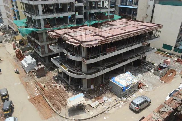 Looking down on the topmost slabs, the streets and the parked cars laid out all around — Prithvi, Karanjade