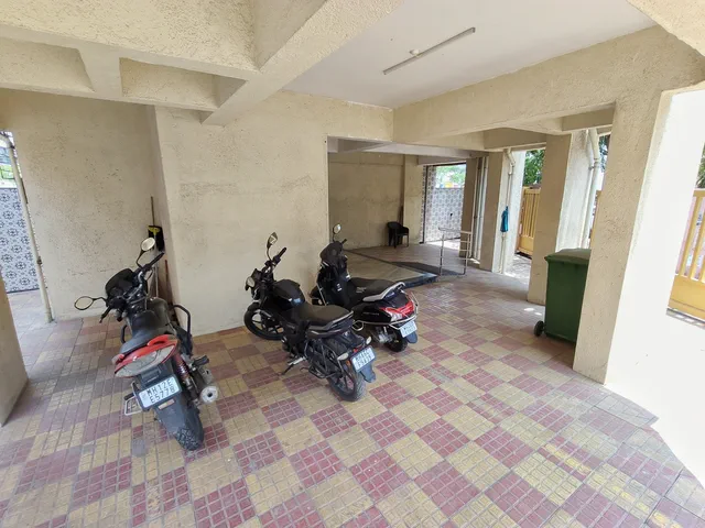 Motorcycles parked between the columns on the checkered tiled parking floor — Shaurya